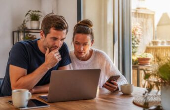 Vakanties vergelijken met laptop en smartphone aan de keukentafel